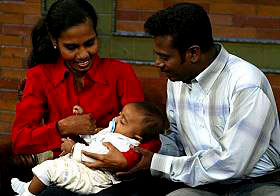 Jenita Jeyarajah, left, and Murugupillai Jeyarajah hold their son Abilass Jeyarajah or Baby 81