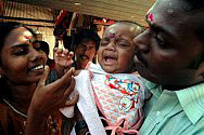 Jenita Jeyarajah, left, and Murugupillai Jeyarajah hold their son Abilass Jeyarajah or Baby 81