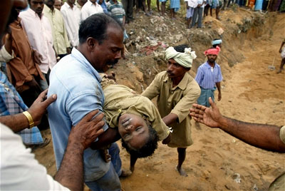A father carries his child to a mass grave